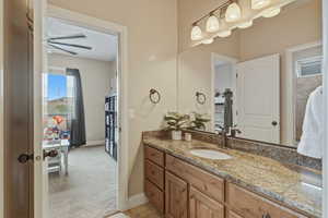 Bathroom with vanity, light colored carpet, and healthy amount of natural light
