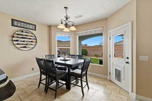 Dining area with stone tile flooring and suspended lighting