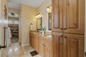 Bathroom featuring stone tile flooring and double vanity