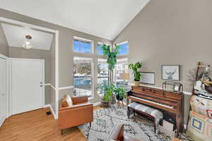 Living area with lofted ceiling and light wood-type flooring