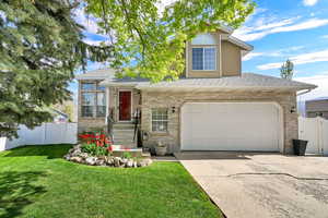 View of front of home with roof with shingles, brick siding, and concrete driveway
