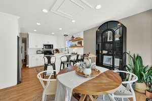 Dining area with light wood-style flooring and recessed lighting