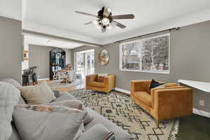 Living room featuring ceiling fan, a textured ceiling, and crown molding
