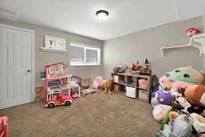 Game room with carpet and a textured ceiling