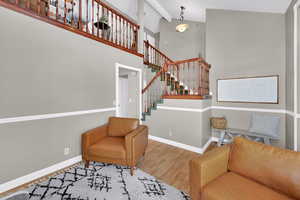 Sitting room with wood finished floors and lofted ceiling