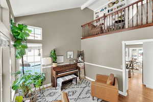 Living area with lofted ceiling and wood finished floors