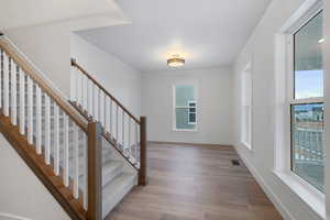Stairway with wood finished floors and baseboards