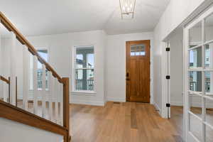 Foyer entrance featuring light wood-style flooring and hanging lights