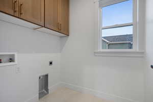 Laundry room featuring cabinet space, hookup for an electric dryer, and hookup for a washing machine