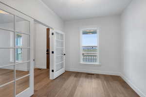 Spare room with light wood-type flooring and french doors