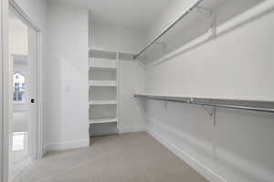 Walk in closet featuring light carpet