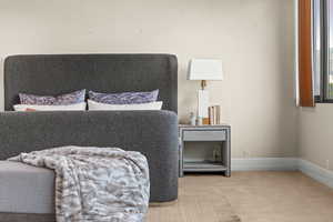 Bedroom featuring carpet and baseboards