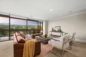 Living area with carpet floors, expansive windows, crown molding, a mountain view, and recessed lighting