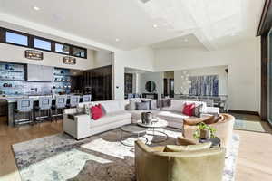 Living room featuring light wood-type flooring, a high ceiling, and recessed lighting