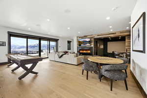 Playroom with a fireplace, light wood finished floors, and recessed lighting