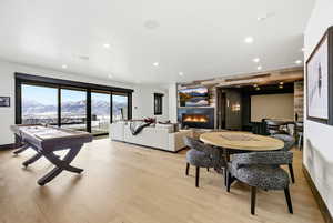 Game room featuring a large fireplace, recessed lighting, and light wood-type flooring