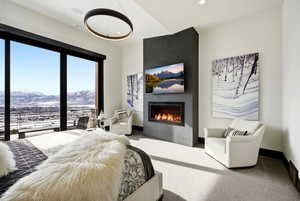 Carpeted bedroom with a mountain view, a fireplace, and access to exterior
