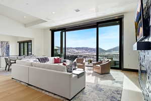 Living area with light wood-style floors, recessed lighting, and a stone fireplace