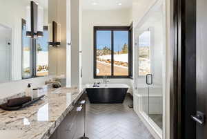 Full bathroom with a shower stall, double vanity, and a freestanding bath