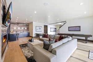 Living area featuring a fireplace, light wood-style floors, recessed lighting, and an accent wall