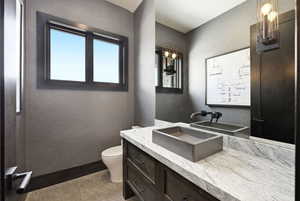 Half bathroom with a textured wall and vanity