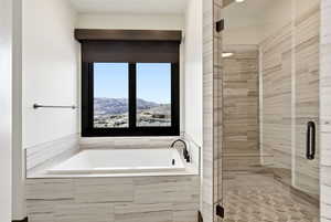 Full bath featuring a shower stall, a mountain view, and a garden tub
