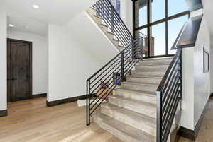Stairs with baseboards and wood finished floors