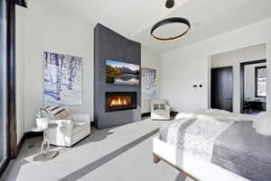 Bedroom with carpet flooring and a large fireplace
