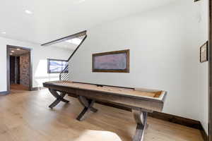 Rec room with light wood-style floors and baseboards