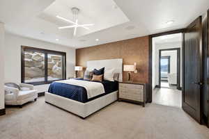 Carpeted bedroom with an accent wall, recessed lighting, and a tray ceiling