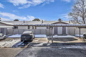 View of front of house featuring a gate, covered parking, and stucco siding