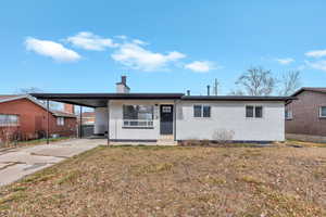 Ranch-style house with brick siding, a chimney, concrete driveway, a carport, and a porch