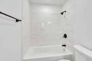 Full bathroom with toilet and shower / washtub combination