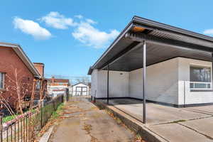 View of home's exterior featuring an outbuilding, brick siding, and a carport