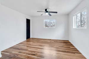 Empty room with light wood-style flooring and ceiling fan