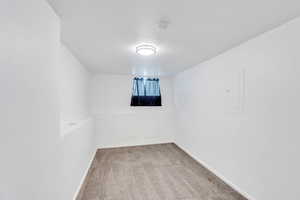 Empty room with light carpet and electric panel
