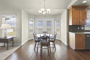 Dining space with dark wood-style floors, hanging lights, and a mountain view
