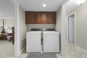 Laundry area with cabinet space, washing machine and dryer, and a textured ceiling