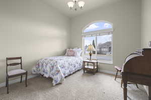Bedroom with suspended lighting and light colored carpet