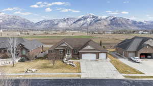 View of front of home featuring concrete driveway, an attached garage, a mountain view, and brick siding