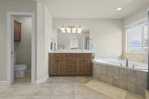 Bathroom with double vanity, a garden tub, light tile patterned flooring, a stall shower, and recessed lighting