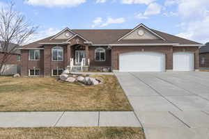 Ranch-style home featuring a front lawn, brick siding, a shingled roof, and an attached garage