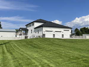 View of side of home featuring stucco siding, stone siding, a shingled roof, and a garage