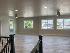Unfurnished room with a ceiling fan, a textured ceiling, recessed lighting, and light wood finished floors