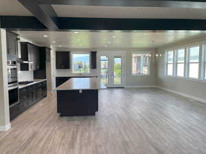 Kitchen featuring a center island, french doors, dark cabinetry, and light wood-type flooring
