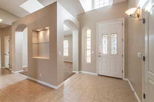 Foyer entrance featuring arched walkways and light tile patterned floors