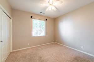Unfurnished bedroom with a closet, carpet flooring, and ceiling fan