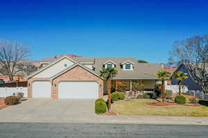 View of front of home featuring a porch, an attached garage, concrete driveway, brick siding, and a tiled roof