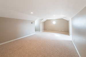 Additional living space featuring carpet, vaulted ceiling, and recessed lighting