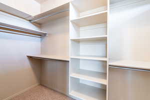Walk in closet featuring light colored carpet